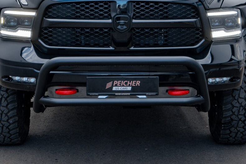 Closeup of a black bullbar fitted to a black Dodge ram with offroad tires