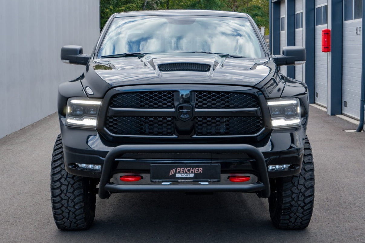 Front view of a black bullbar fitted to a lifted Dodge Ram with offroad tires