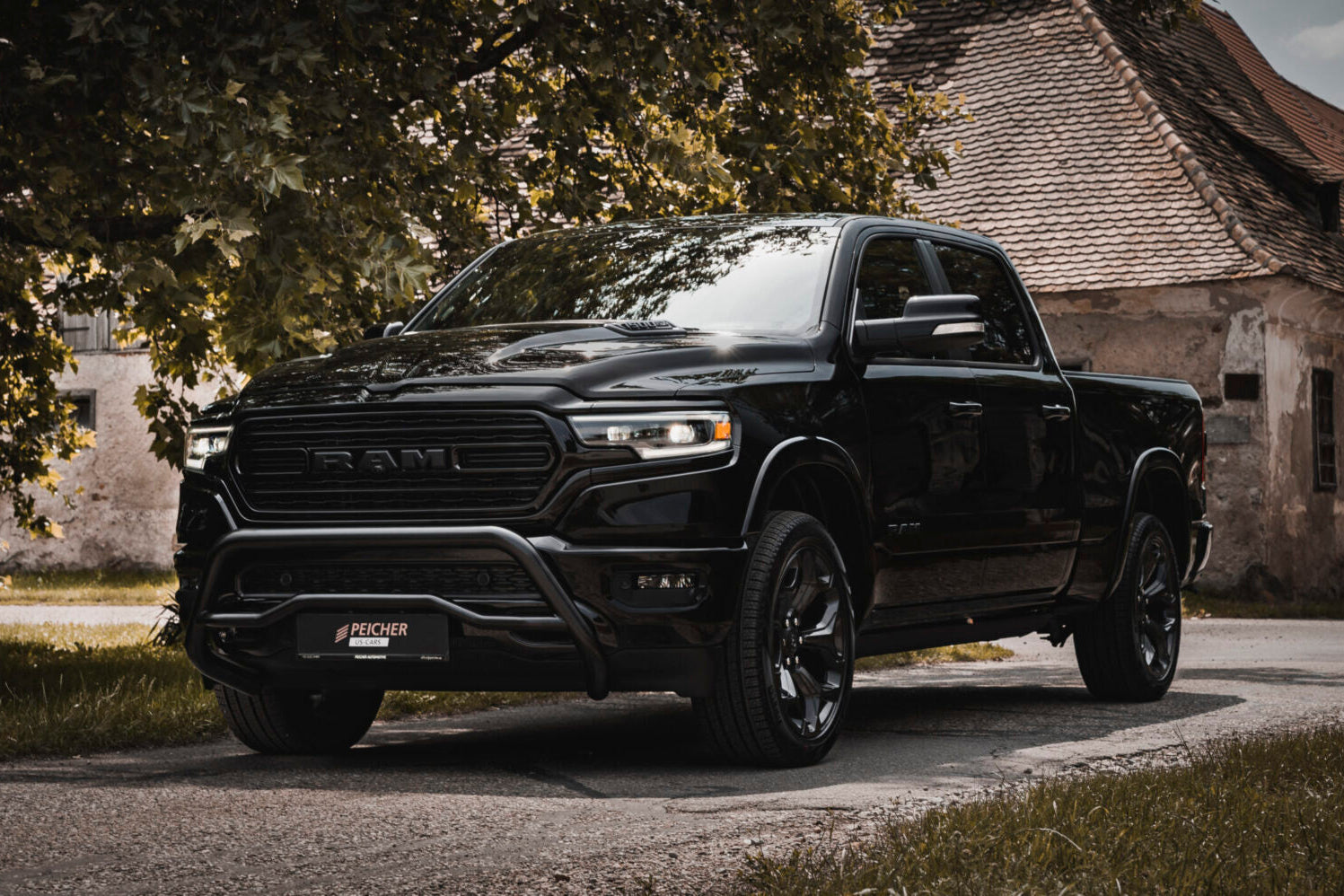 Black Dodge Ram with a black bullbar parked next to a home