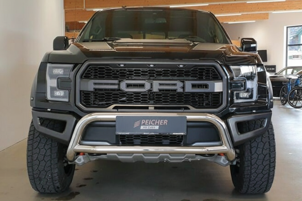 Frontal view of a black Ford F150 Raptor with a stainless steel bullbar